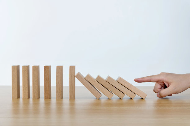 女人用手推着多米诺骨牌图片下载