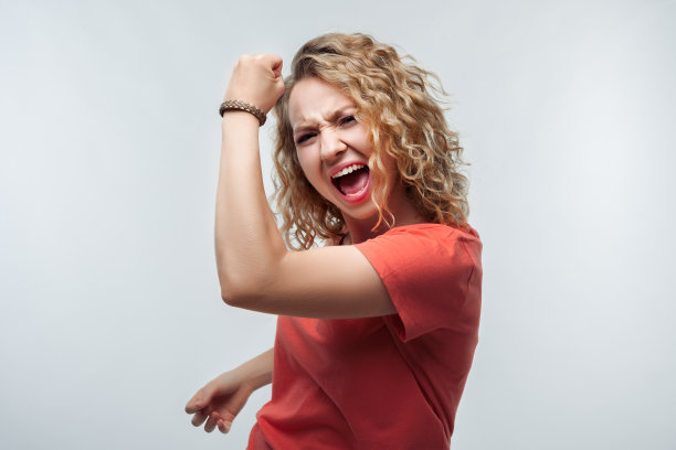 年轻快乐的女人微笑着做胜利者的手势。工作室拍摄，白色背景，孤立图片下载