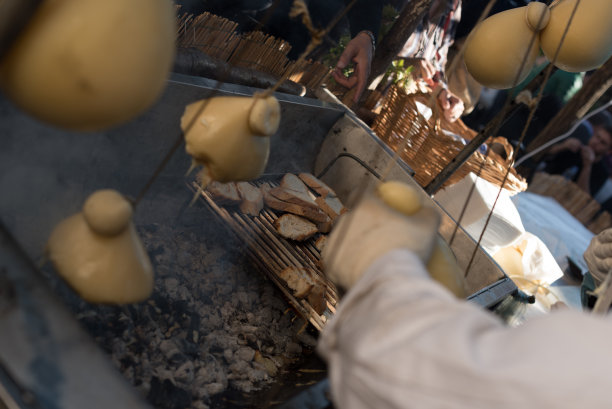 意大利街头食品。在坎帕尼亚小镇蒙特拉的集市上，Caciocavallo在烤架上融化了。Caciocavallo“挂”。栗的节日。特写照片。图片下载