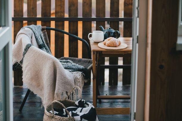 秋天的早餐，热茶和羊角面包，在一个木制乡村别墅舒适的阳台上。秋天的气氛。慢生活的概念。图片下载
