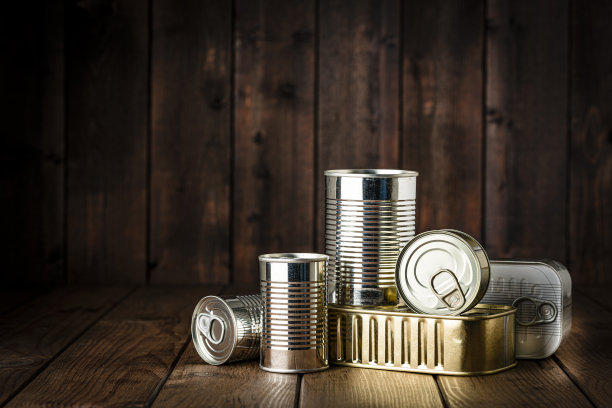 深色的木桌上放着罐装食品。本空间图片下载