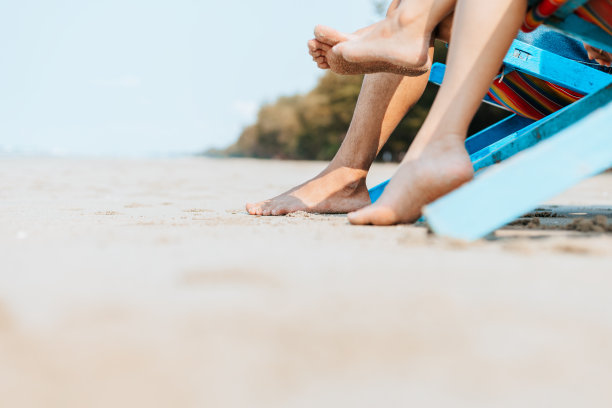 一对夫妇坐在海滩的躺椅上。蜜月，爱情，旅行或度假的概念。图片下载