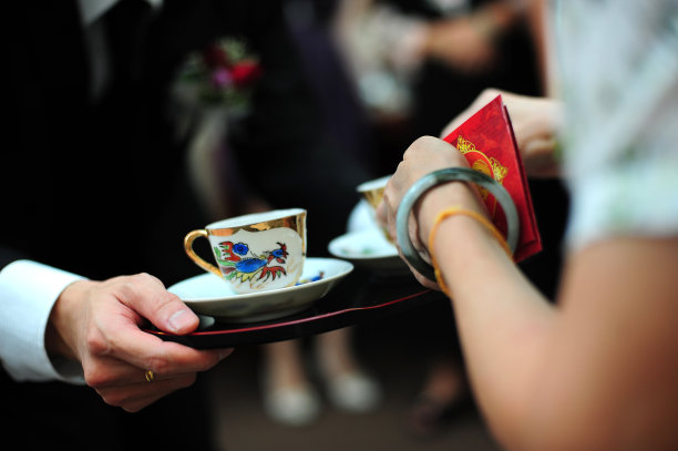 新婚夫妇在中国传统茶道上给老人斟茶图片下载