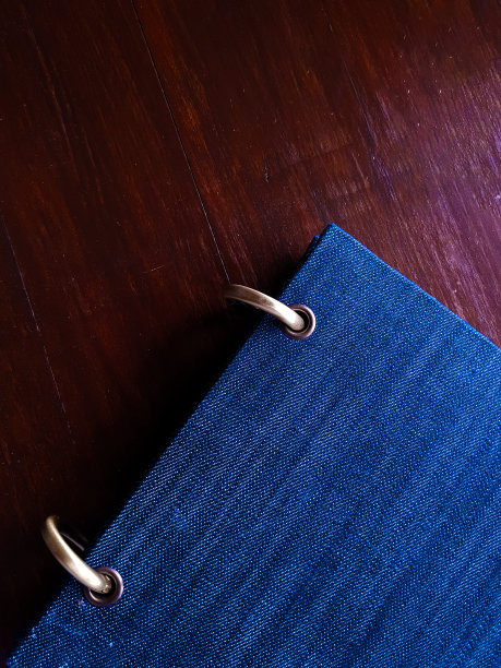 深蓝的笔记本，深棕色的木制背景。记事本放在桌上。为你的文本。图片下载