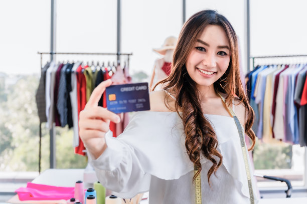 美丽的女子设计师站在和手牵手信用卡秀图片下载