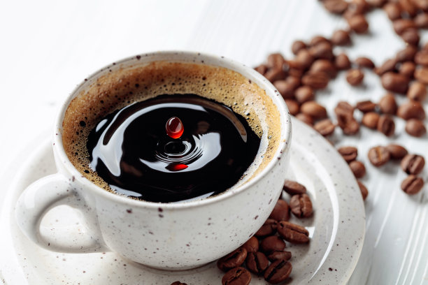 白木桌上放着黑咖啡和咖啡豆。图片下载