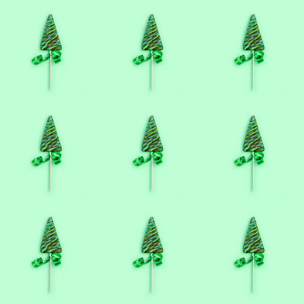 彩色糖果创意无缝图案新年或圣诞节。绿色背景下的棒棒糖形状像圣诞树。节日快乐，庆祝甜蜜。图片下载