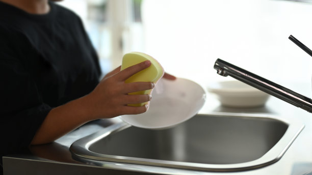 一个年轻的女孩在厨房的水槽上洗手的镜头。图片下载