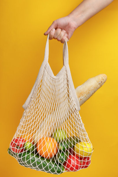 女人拿着网状购物袋。图片下载