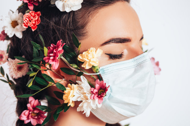 美丽的仙女女人在一个白色的背景医学面具，在她的头发她有花和花圈图片下载