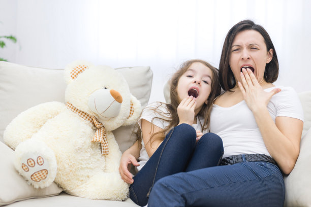 妈妈和她想睡觉的女儿的照片。图片下载