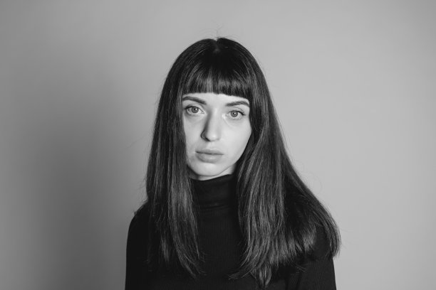 一个年轻女子的画室肖像，背景是纯灰色图片下载