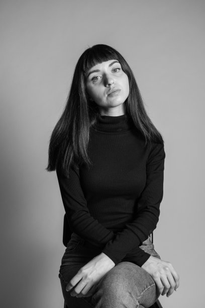 一个年轻女子的画室肖像，背景是纯灰色图片下载