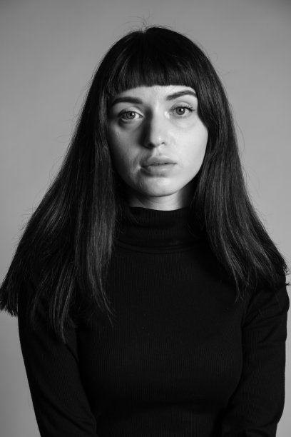 一个年轻女子的画室肖像，背景是纯灰色图片下载