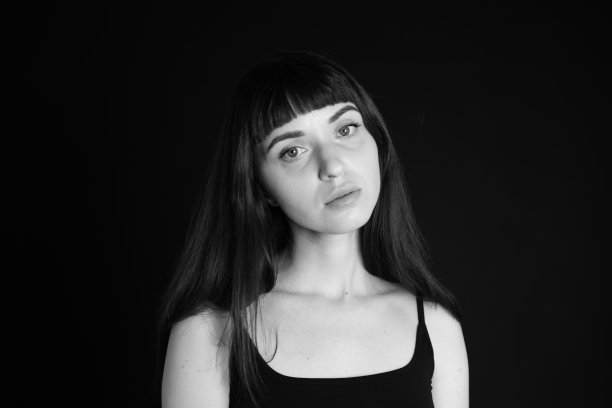 一个年轻女子的画室肖像，背景是纯黑色图片下载