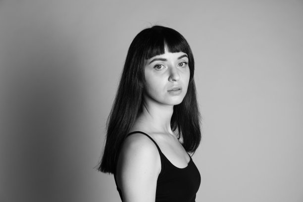 一个年轻女子的画室肖像，背景是纯灰色图片下载