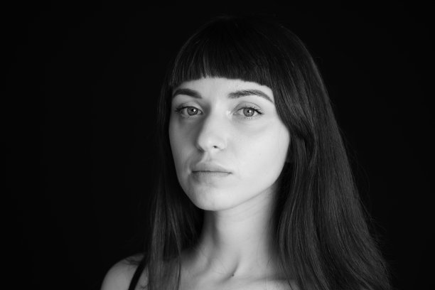 一个年轻女子的画室肖像，背景是纯黑色图片下载