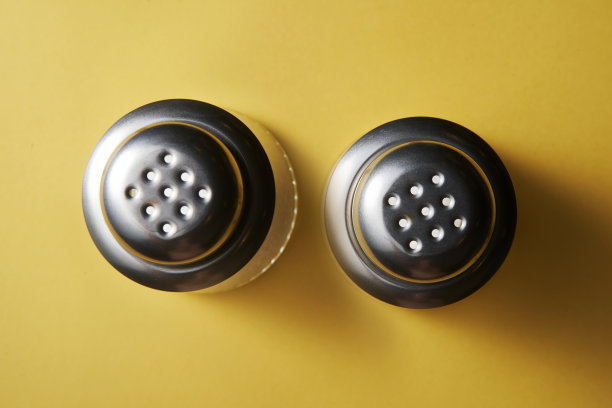 黄色背景上的盐和胡椒容器图片下载