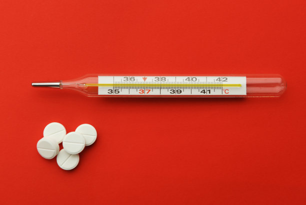 红色背景上的温度计药丸。流感疫情,冠状病毒。温度37.2摄氏度。图片下载