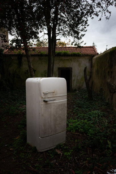 昏暗后院的老式白色冰箱图片下载