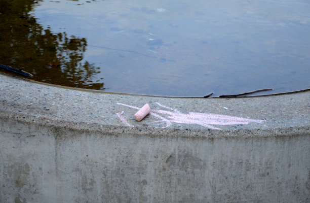 在一个儿童游乐场，中间有一扇带网子的铁门。用木头和灰色混凝土做的栅栏。保护沙坑，防止狗狗和它们的主人随地小便。饮水机、圆形喷泉、排水管图片下载