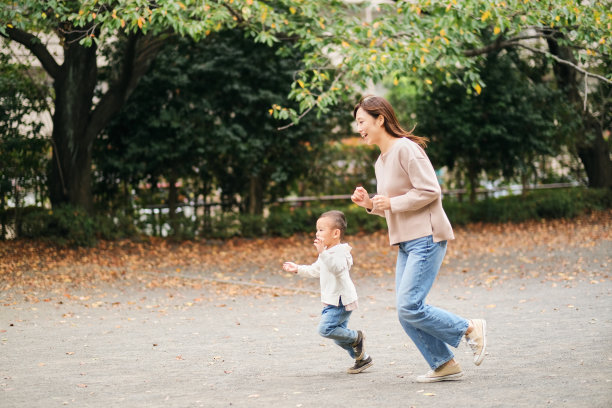 妈妈和孩子在公园的操场上跑步图片下载