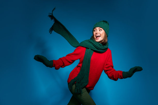 积极开朗的女孩的照片有趣的圣诞新年假期跑玩赶上游戏朋友穿连指手套套头衫裤子裤子孤立在梯度蓝色背景图片下载