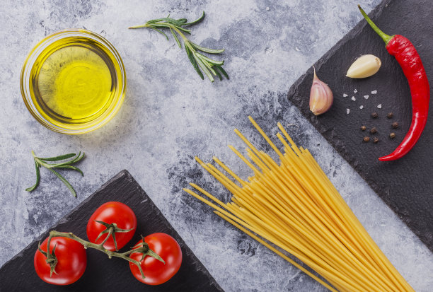 桌上放着意大利面，红番茄，大蒜和香草图片下载