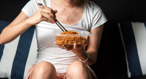 女子在家吃外卖炒面图片下载