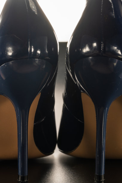 女性高跟鞋的蓝色和光泽的黑色背景图片下载