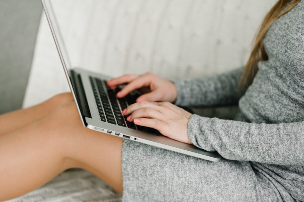 使用笔记本电脑在家办公的女性。在家里用笔记本打字的女孩。圣诞节销售。计划假期。网络搜索。关闭了。图片下载