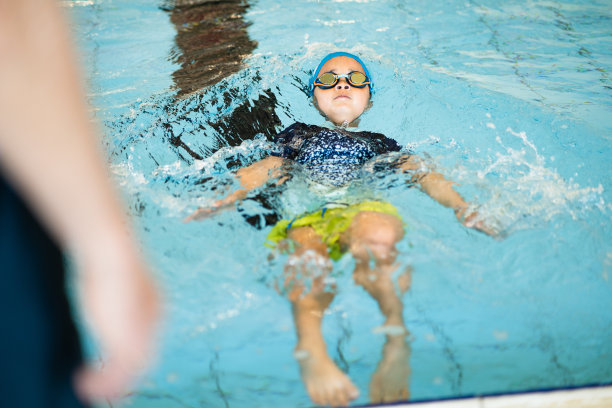 教练教孩子仰泳。图片下载