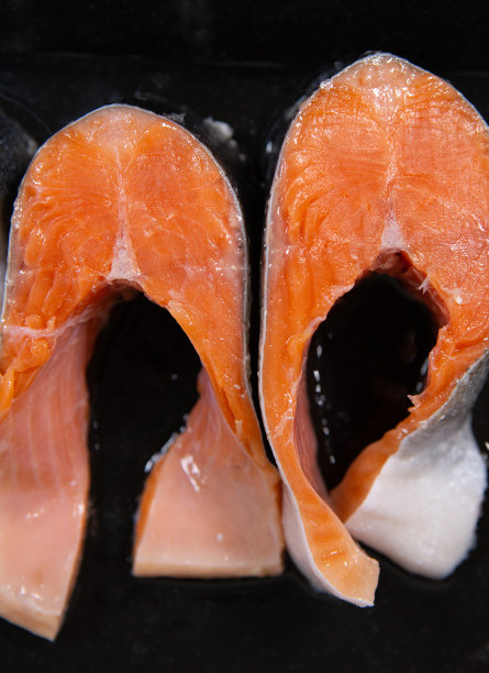 生的，新鲜的鳟鱼排在烤盘和植物油。生鳟鱼，红鱼。在家用烤箱煮鳟鱼是一种健康的食物理念。图片下载