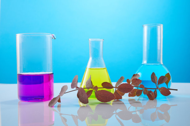 试管中的花和植物在黄色背景上。生物学研究的概念。图片下载