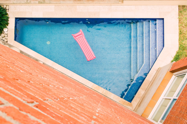 漂浮在游泳池中的充气床垫图片下载