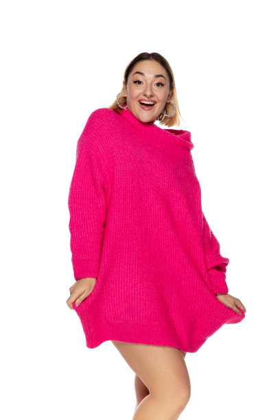 美丽的年轻女子在明亮的粉红色舒适的毛衣，长袖孤立在白色工作室背景图片下载