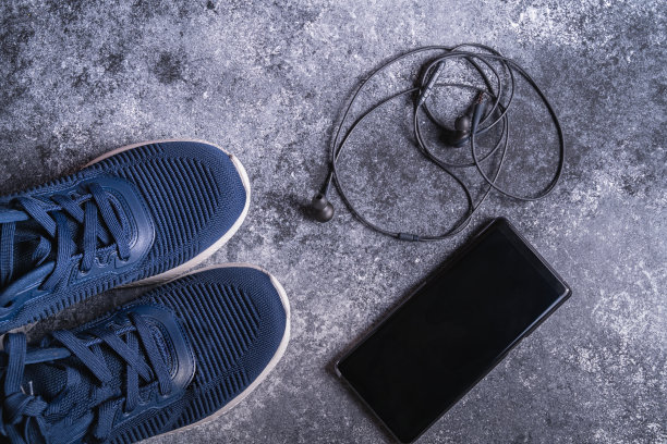 健身设备与运动鞋，智能手机和耳机灰色背景，俯视图。副本的空间。图片下载