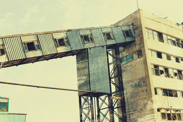 旧的，生锈的门式起重机在铁路上，一个废弃的混凝土工厂。危机、经济崩溃和生产能力的关闭导致了崩溃。全球灾难。一张古老照片的效果。图片下载