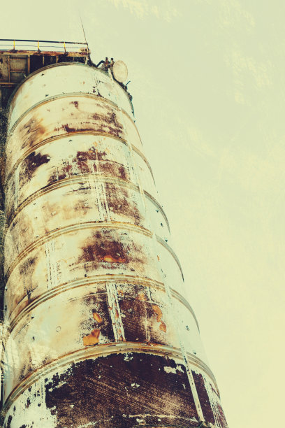 旧的，生锈的门式起重机在铁路上，一个废弃的混凝土工厂。危机、经济崩溃和生产能力的关闭导致了崩溃。全球灾难。一张古老照片的效果。图片下载