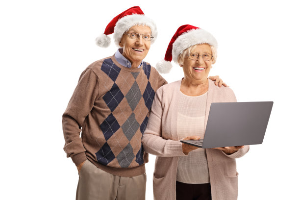 戴着圣诞老人帽，拿着笔记本电脑的快乐老人和老人图片下载