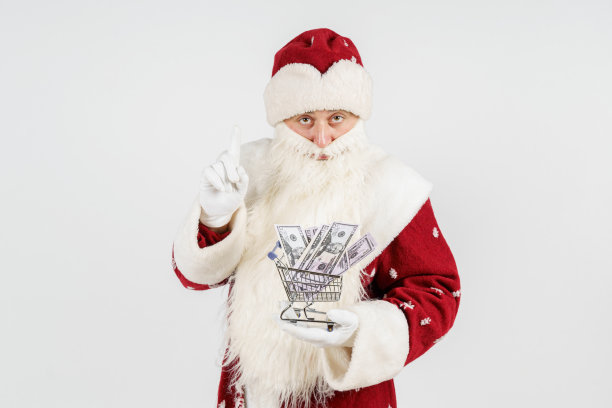 圣诞老人手里拿着一辆装着钱的车。孤立在白色图片下载