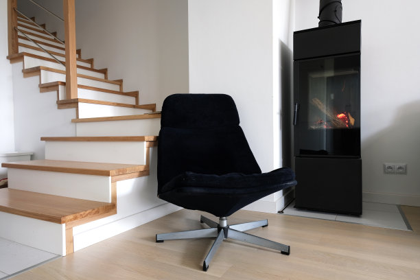 现代斯堪的纳维亚客厅与海军蓝扶手椅，楼梯和现代独立式现代壁炉。图片下载