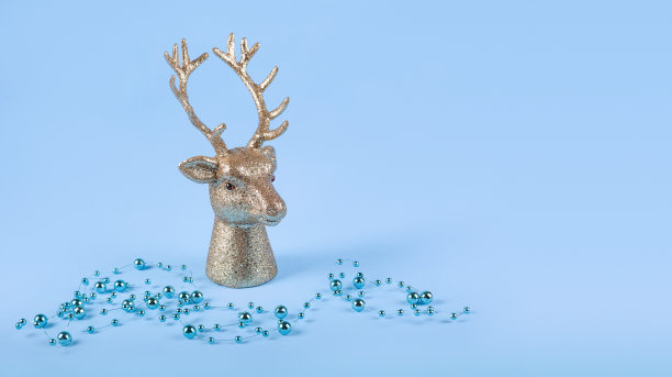 圣诞构图在极简风格-金鹿头在蓝色背景与新年球，灯。本空间图片下载