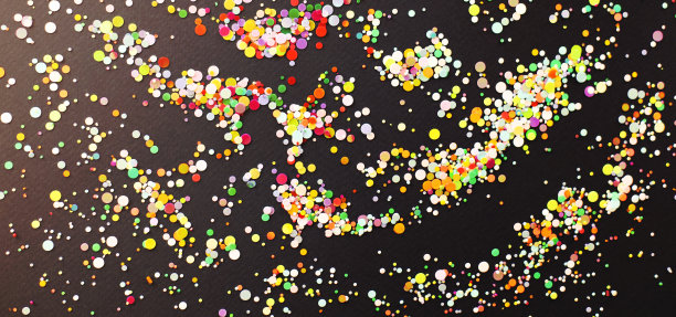 深色的桌子上放着五颜六色的五彩纸屑图片下载