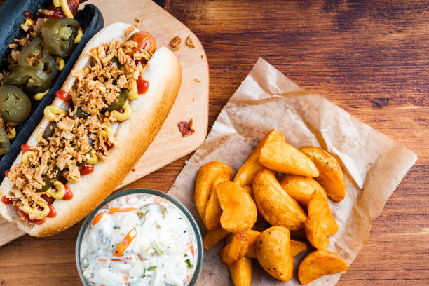 美国传统快餐热狗，新鲜的有机面包，小面包，白小麦和黑炭香肠，番茄酱，芥末配烤洋葱，泡菜，薯条，卷心菜沙拉图片下载