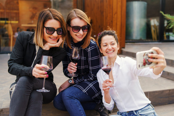 一群女性朋友与葡萄酒的乐趣-女人在房子前面的派对自拍照片-姐妹们在白天进行视频通话图片下载