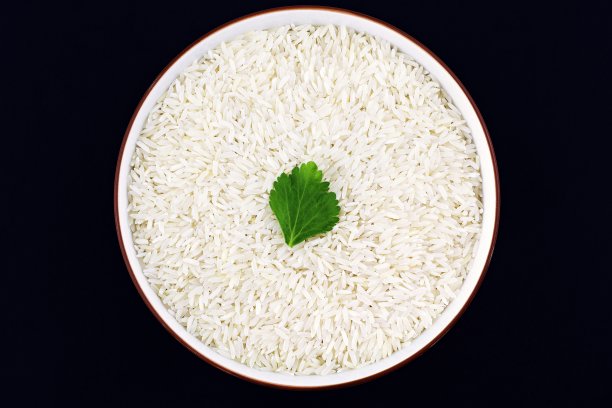 白米碗和绿色蔬菜叶-黑色背景。图片下载