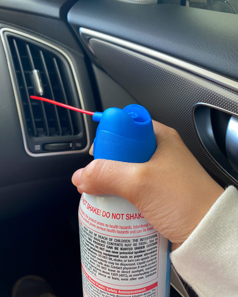 车主使用空气喷粉器清洗汽车的通风口图片下载