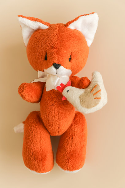 柔软的玩具姜狐狸与鸡在一个轻的背景。图片下载