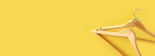 空的木制衣架上的黄色背景与复制空间。销售和购物概念。横幅图片下载